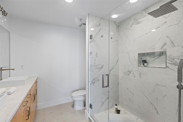 bathroom featuring tile patterned floors, vanity, toilet, and a shower with door