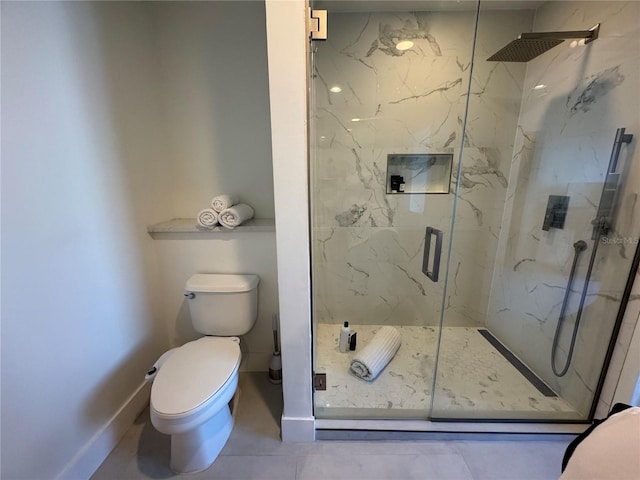 bathroom featuring tile patterned floors, toilet, and a shower with door