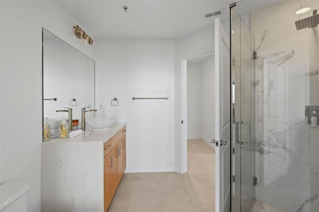 bathroom with tile patterned floors, vanity, a shower with shower door, and toilet