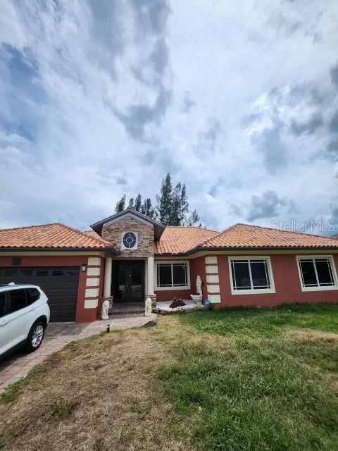 view of front of house featuring a garage and a front lawn