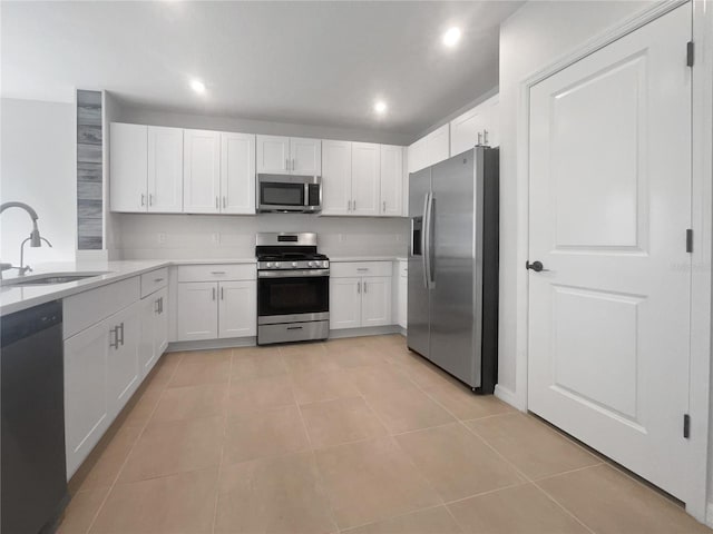 kitchen featuring light tile patterned flooring, sink, white cabinetry, and stainless steel appliances