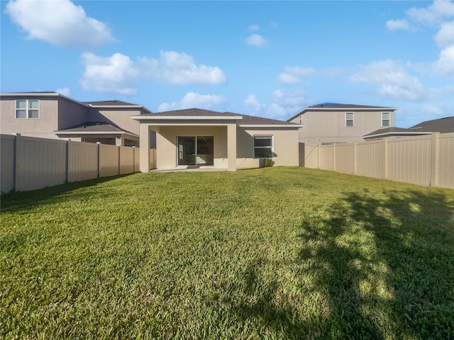 back of property featuring a lawn and a patio