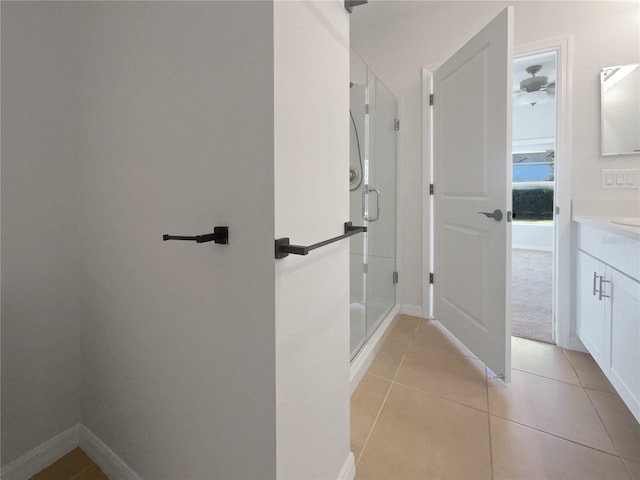 bathroom featuring tile patterned floors, a shower with door, and vanity