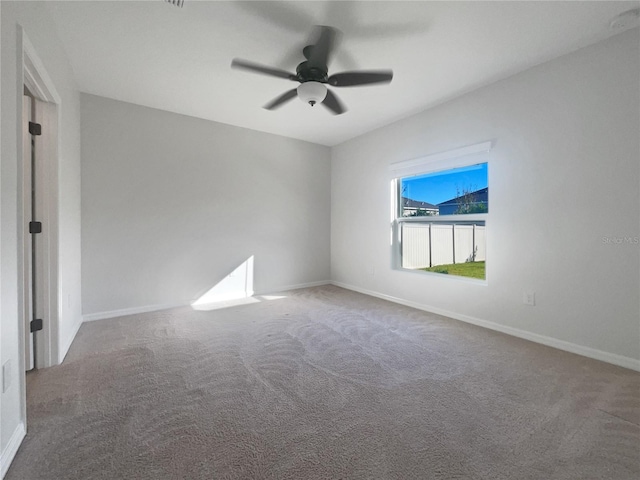 carpeted spare room featuring ceiling fan