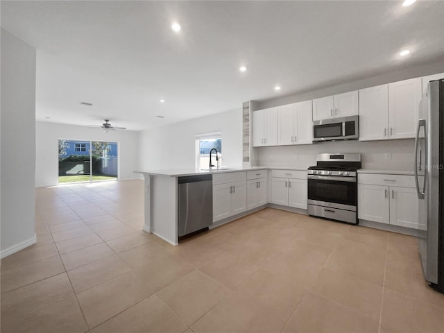 kitchen with white cabinetry, kitchen peninsula, a wealth of natural light, and stainless steel appliances