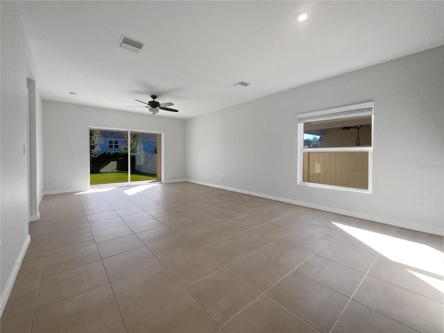 tiled spare room featuring ceiling fan