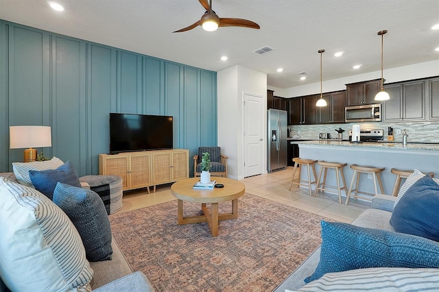 living room featuring ceiling fan and light tile patterned flooring