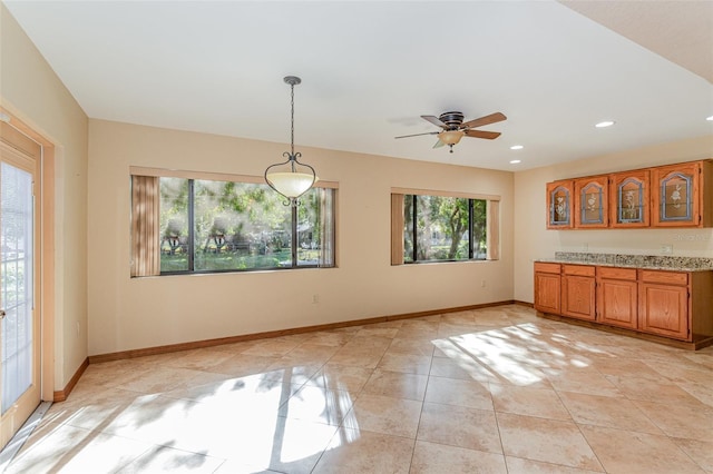 unfurnished dining area with light tile patterned floors and ceiling fan