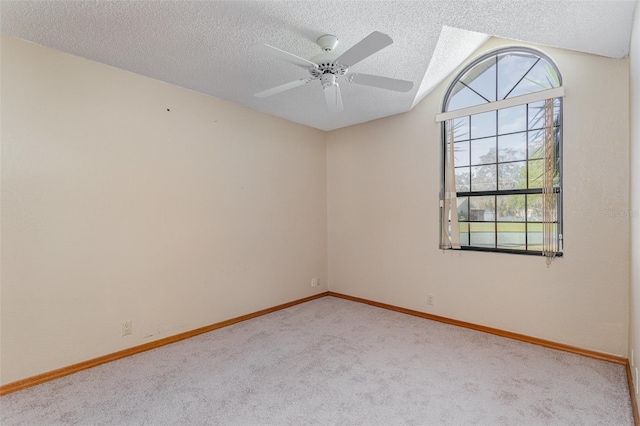 carpeted empty room with ceiling fan, a textured ceiling, and vaulted ceiling