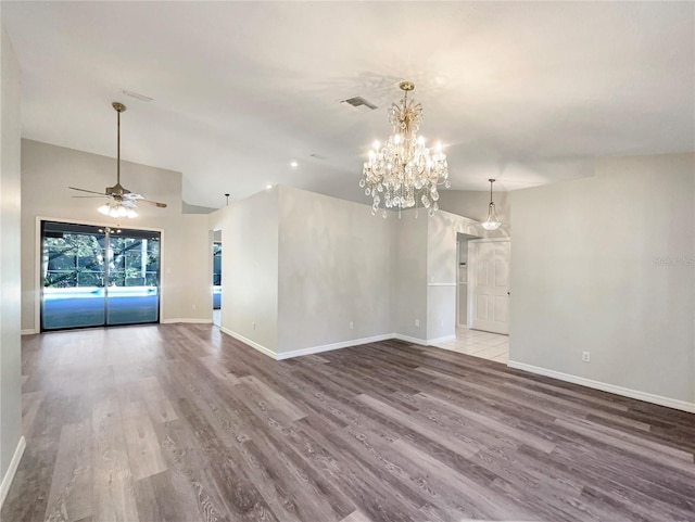 spare room with ceiling fan with notable chandelier and light hardwood / wood-style floors