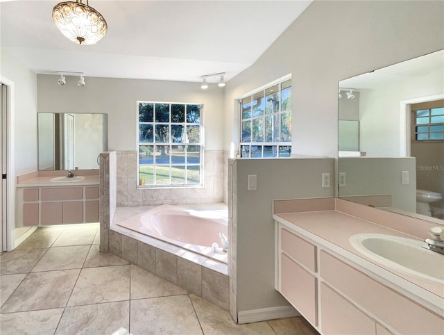 bathroom with tile patterned flooring, vanity, tiled tub, and a chandelier