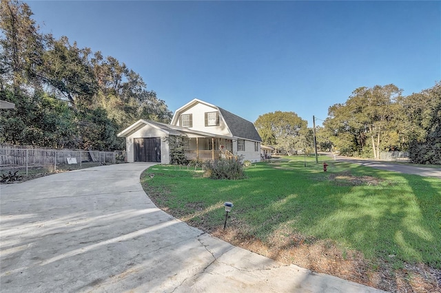 view of front of property with covered porch, a garage, and a front yard