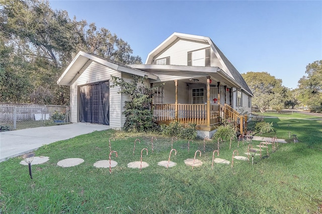 view of front of home with a garage, covered porch, and a front yard