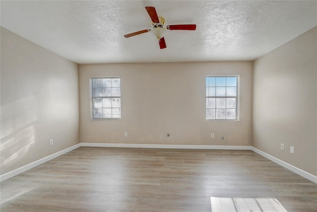 spare room with ceiling fan, light hardwood / wood-style flooring, and a textured ceiling