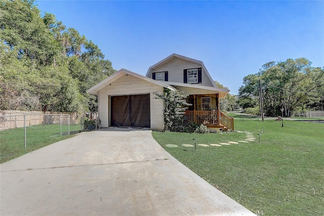 view of front facade with driveway, fence, a front yard, and covered porch
