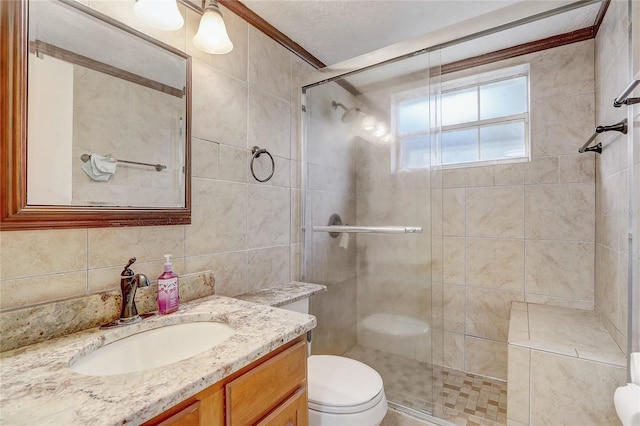 bathroom featuring toilet, tile walls, a shower stall, vanity, and ornamental molding