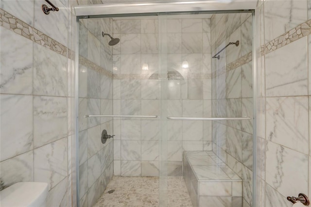 full bathroom with a shower stall and toilet