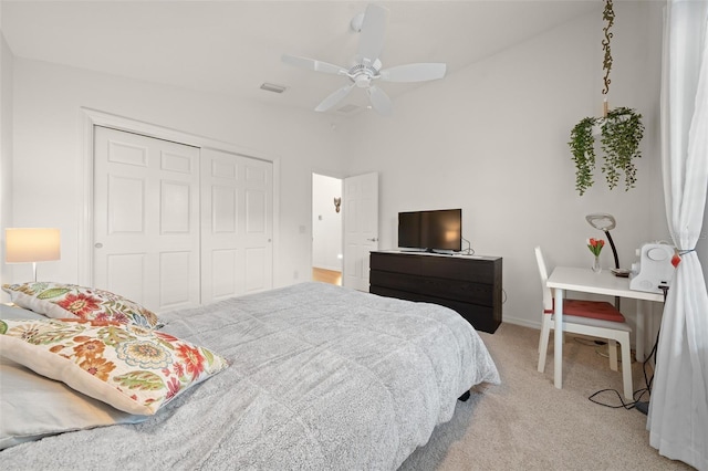 bedroom featuring light colored carpet, a closet, and ceiling fan