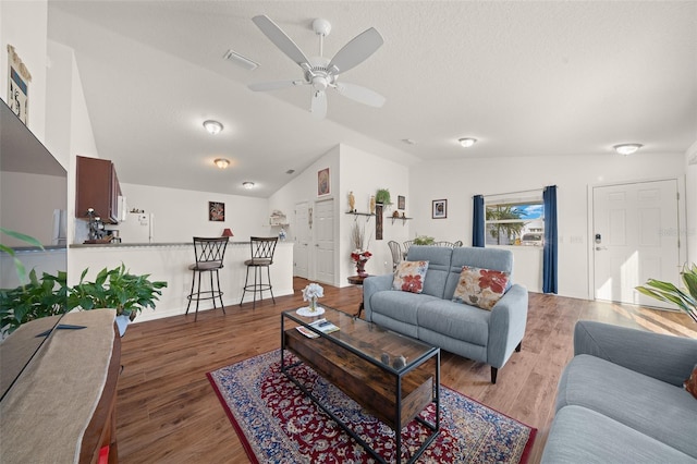 living room featuring a textured ceiling, ceiling fan, dark hardwood / wood-style floors, and lofted ceiling