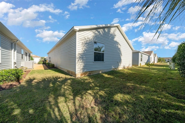 view of side of home featuring a yard and central AC unit