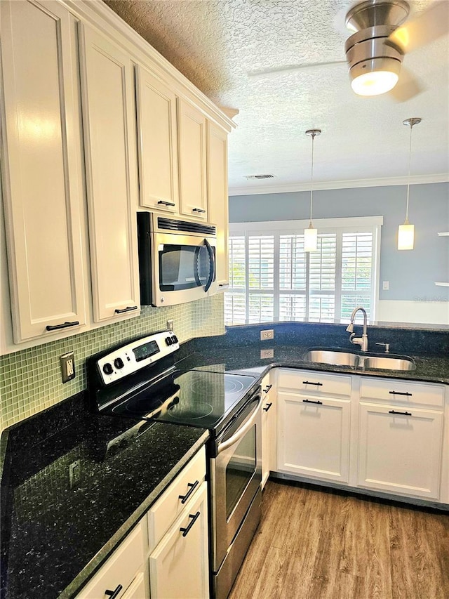 kitchen featuring crown molding, light wood-type flooring, sink, and appliances with stainless steel finishes