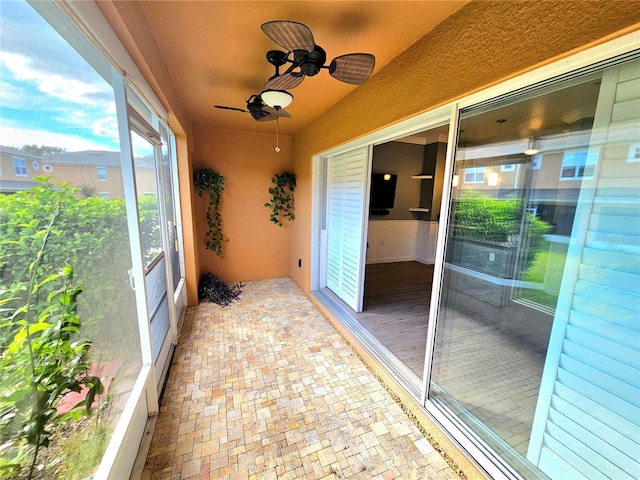 unfurnished sunroom featuring ceiling fan