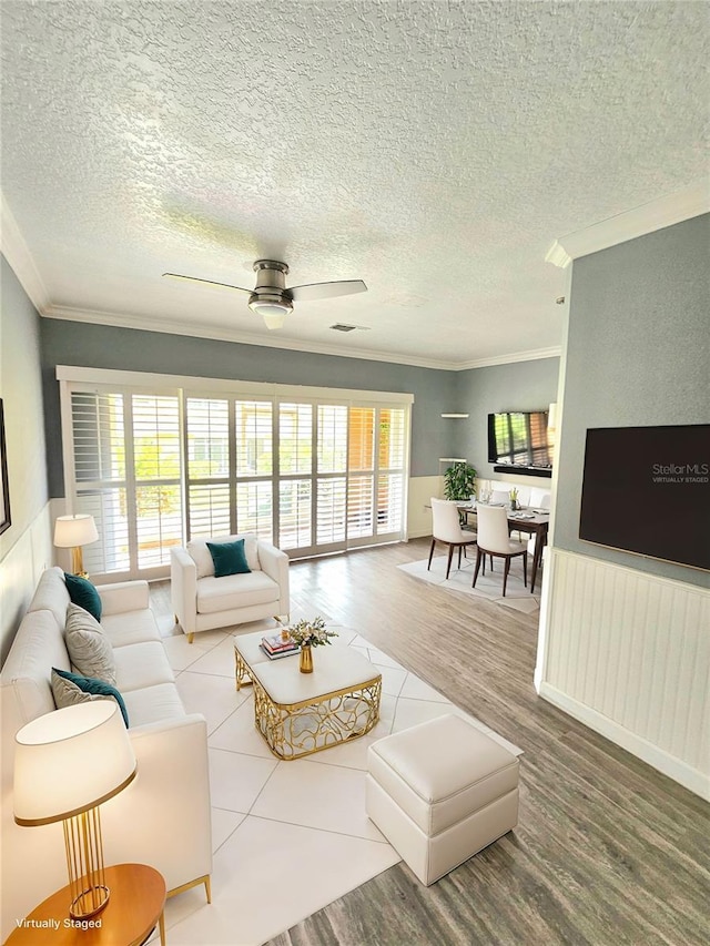 living room with ceiling fan, crown molding, a healthy amount of sunlight, and hardwood / wood-style flooring