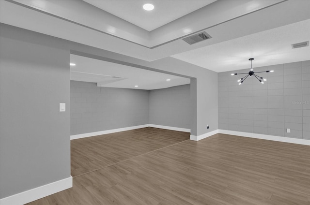 basement with wood-type flooring and an inviting chandelier