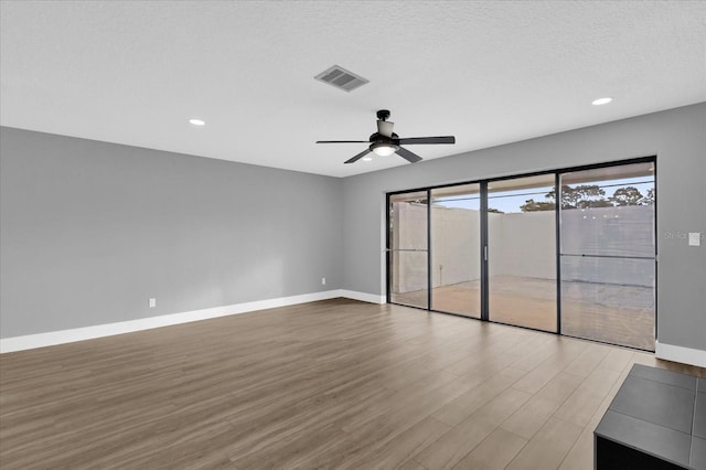 unfurnished bedroom with hardwood / wood-style floors, a textured ceiling, and ceiling fan