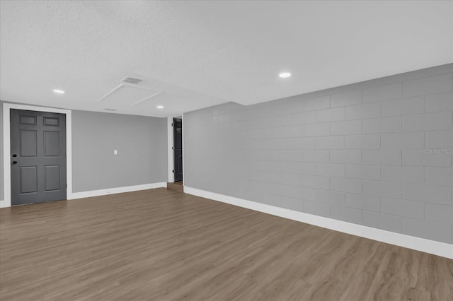 basement featuring a textured ceiling and hardwood / wood-style flooring