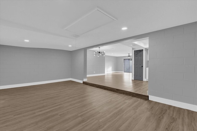 unfurnished living room featuring hardwood / wood-style floors and ceiling fan with notable chandelier