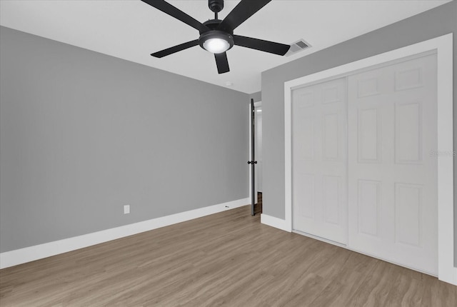 unfurnished bedroom with light wood-type flooring, a closet, and ceiling fan