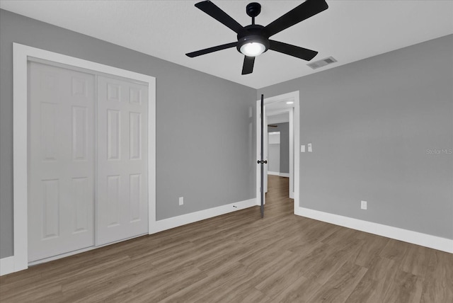 unfurnished bedroom with ceiling fan, a closet, and light hardwood / wood-style floors