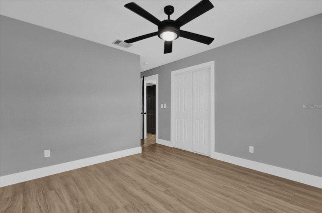 unfurnished bedroom featuring ceiling fan, light wood-type flooring, and a closet