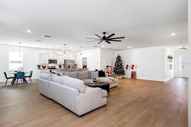 living room featuring light wood-type flooring and ceiling fan