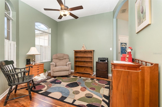 living area featuring hardwood / wood-style floors, ceiling fan, and vaulted ceiling