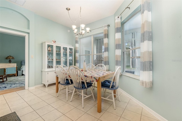 dining space with light tile patterned floors and a notable chandelier