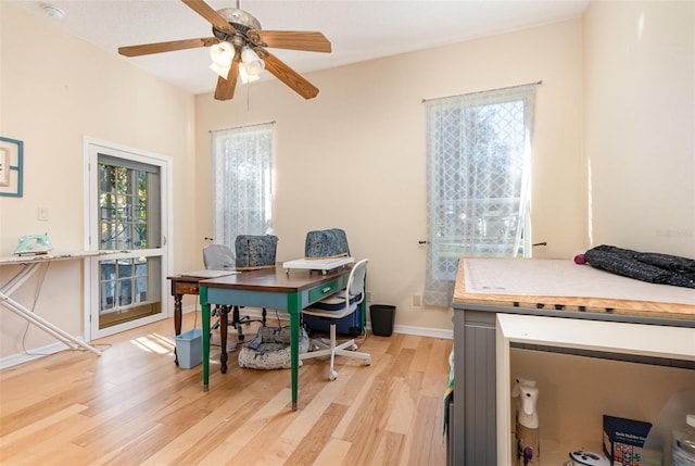 office with light hardwood / wood-style flooring and ceiling fan