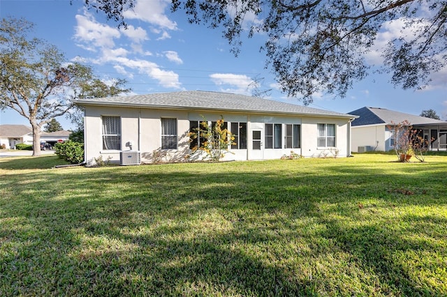 rear view of property featuring a lawn