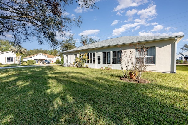 back of house featuring a yard and central AC unit