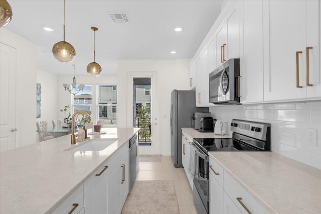 kitchen with stainless steel appliances, white cabinetry, and sink