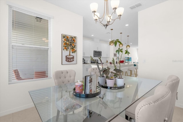 dining area with light tile patterned floors and an inviting chandelier