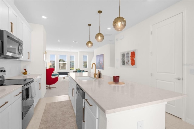 kitchen with pendant lighting, sink, an island with sink, and stainless steel appliances