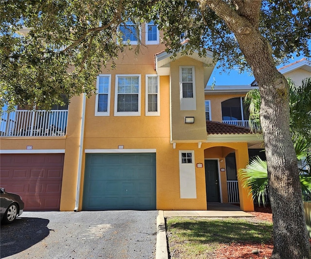 townhome / multi-family property featuring a balcony and a garage