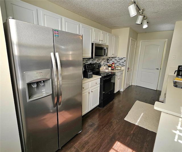 kitchen with decorative backsplash, white cabinets, dark wood-type flooring, and appliances with stainless steel finishes