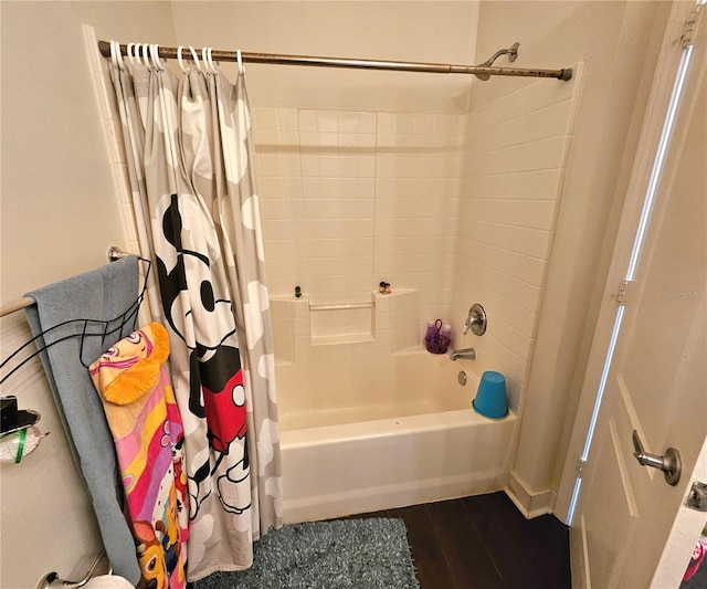 bathroom with wood-type flooring and shower / tub combo