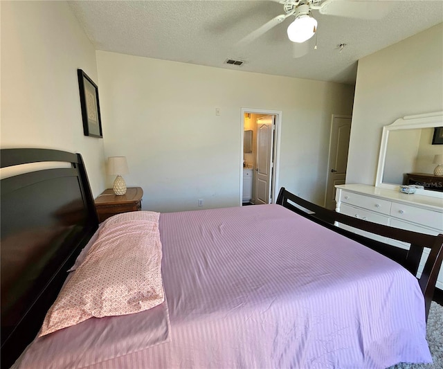 bedroom featuring ceiling fan, a textured ceiling, and connected bathroom