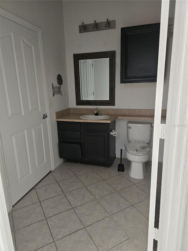 bathroom with tile patterned flooring, vanity, and toilet