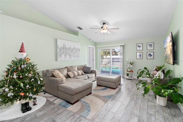 living room featuring ceiling fan, lofted ceiling, and light hardwood / wood-style flooring