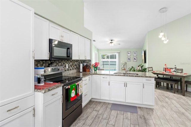 kitchen with electric range, white cabinets, kitchen peninsula, and sink